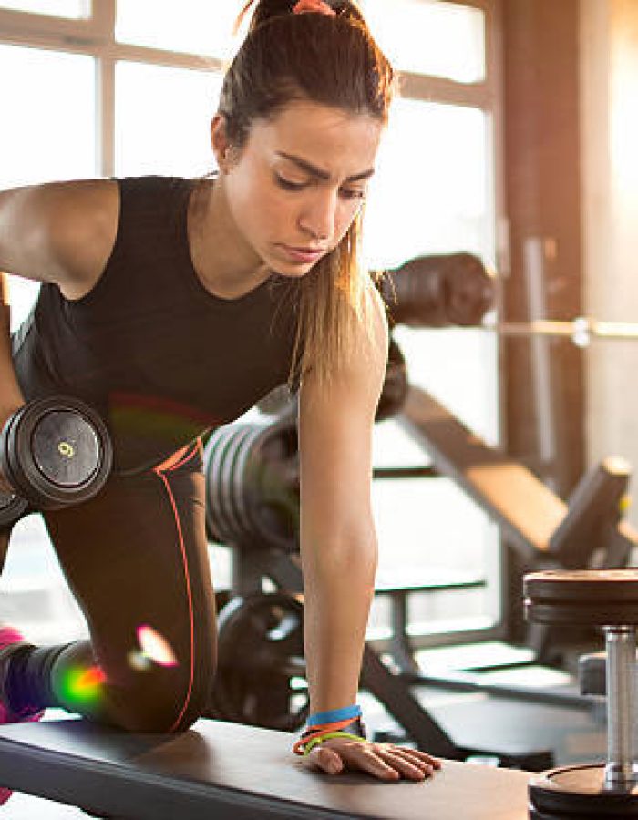 Fitness girl lifting dumbbell in the morning.